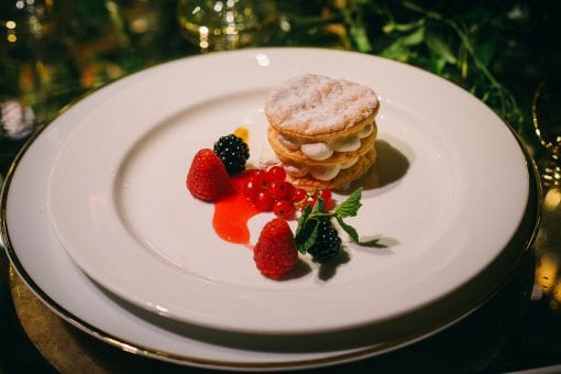 Decadent dessert served with fresh fruit and coolis at a luxurious wedding party