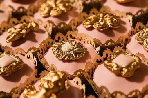 Luxury cupcakes with gold ornate detailing on pink icing