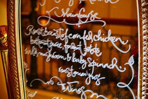 A menu written by a calligrapher on a gold gilt mirror for a lavish birthday party at the Mandarin Oriental Ballroom