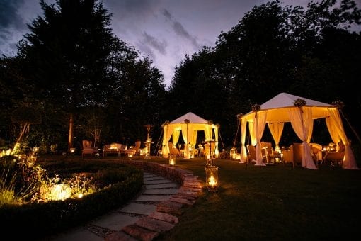 Raj tents beautifully lit with soft seating surrounded by candle light for a private memorial event in Hampstead, London