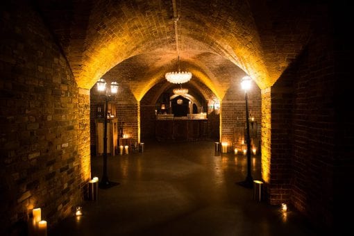 Dark underground room lit with candles and lanterns at One Marylebone