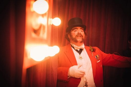 Ringmaster greeting guests at a Moulin Rouge Party in Mayfair