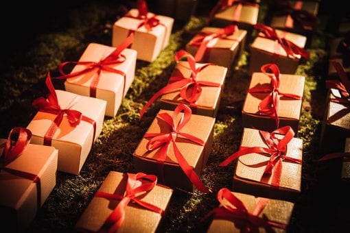 Guest gifts in luxury gold boxed with red satin ribbon at a Mayfair private birthday party