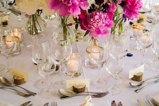 Round table setting in a marquee for a luxury wedding with pink and white peonies